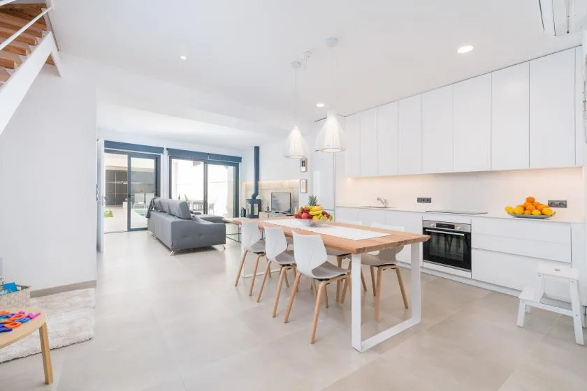 A bright open-plan kitchen and dining area with a table and seating.