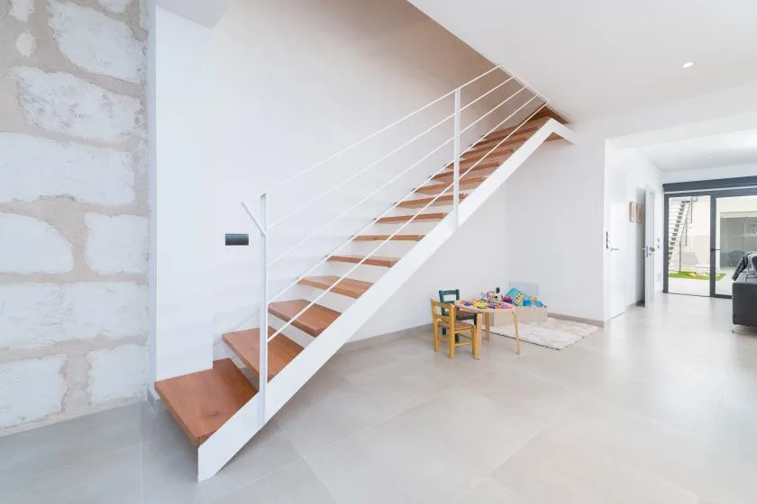 A bright interior with a staircase and a small children's play area.