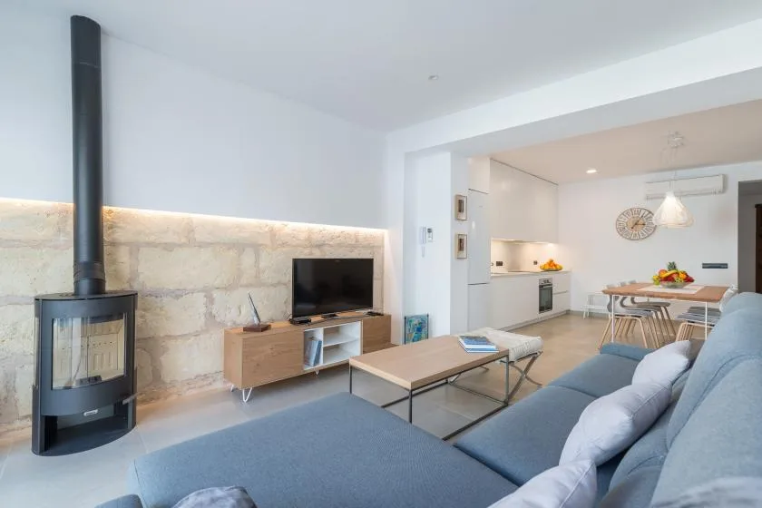 Living room and dining area with a television, seating, and an open kitchen.