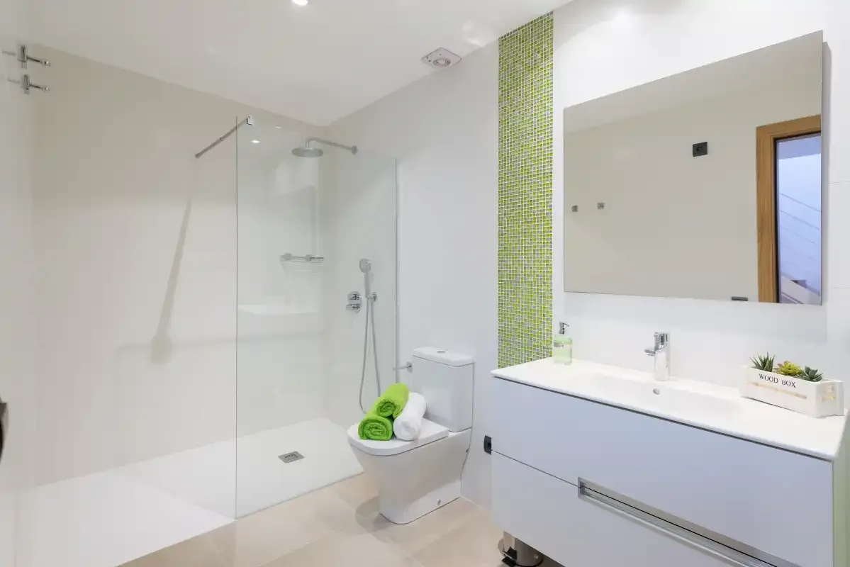 A bright bathroom with a glass shower and a wide sink vanity.