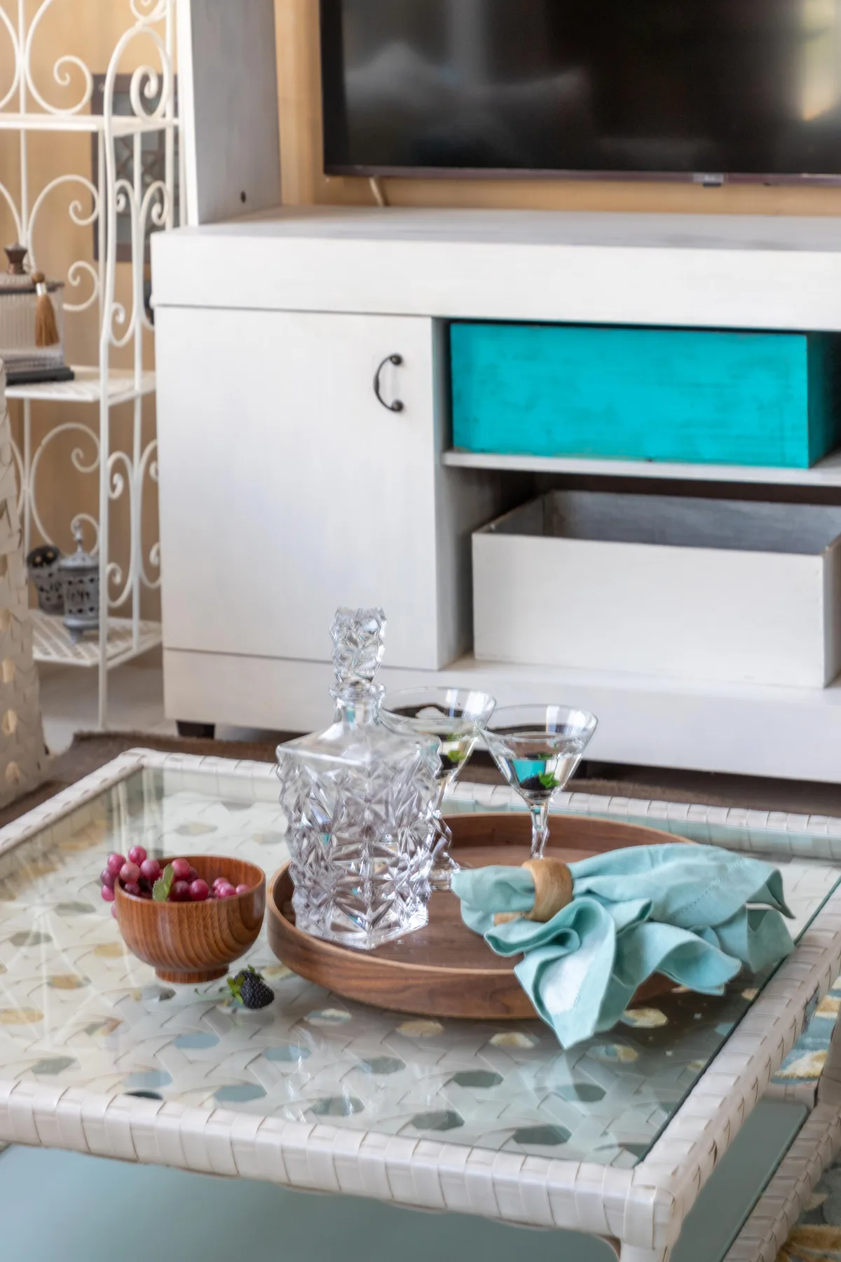 Una sala de estar con una mesa de centro de vidrio y un televisor.