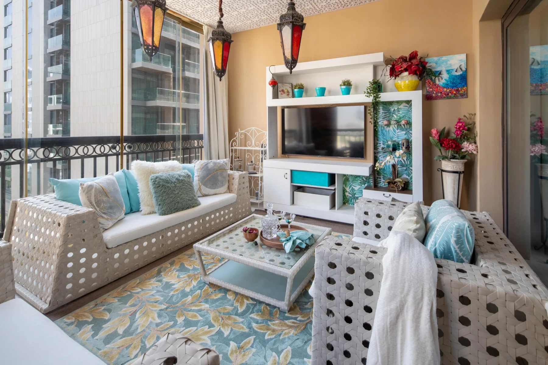 Una luminosa sala de estar con asientos estampados, un televisor y decoración colorida.
