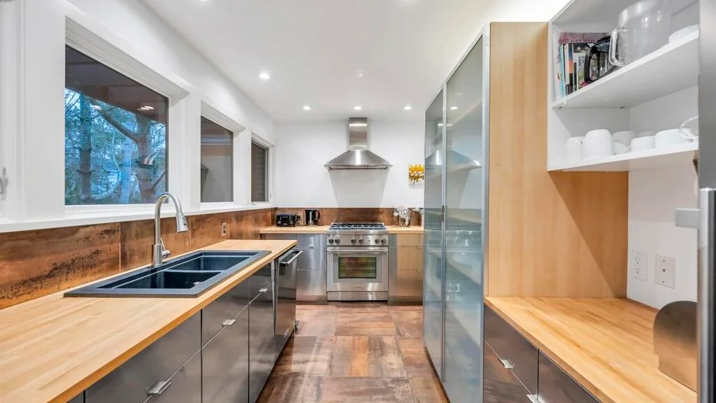 Una cocina moderna y luminosa con una isla central y electrodomésticos de acero inoxidable.