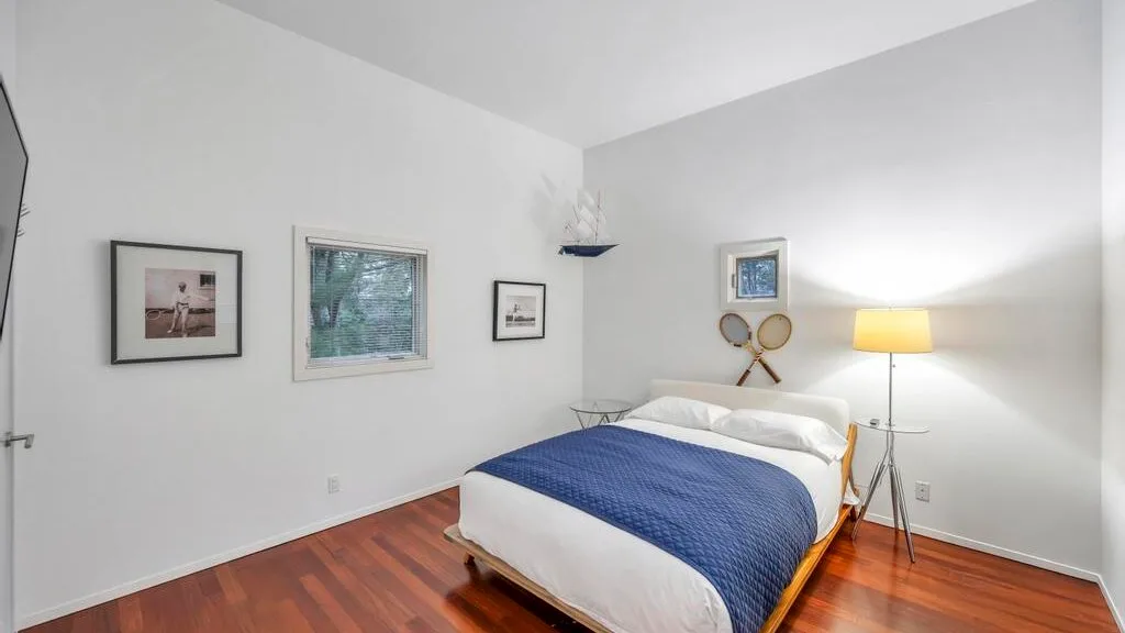 Un dormitorio luminoso con una cama doble cubierta por una manta azul.
