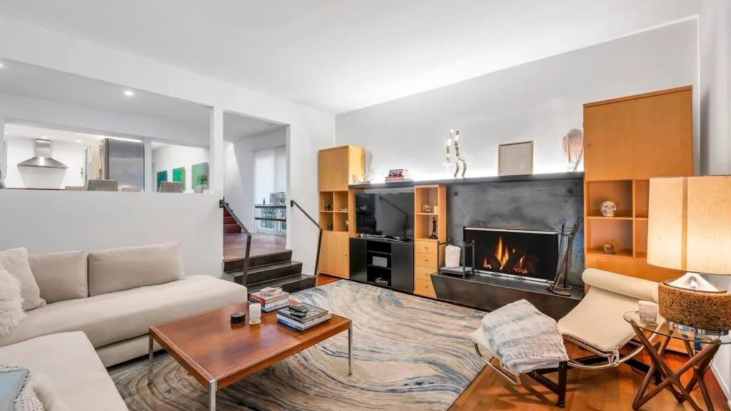 Una sala de estar con asientos alrededor de una mesa de centro y una chimenea.