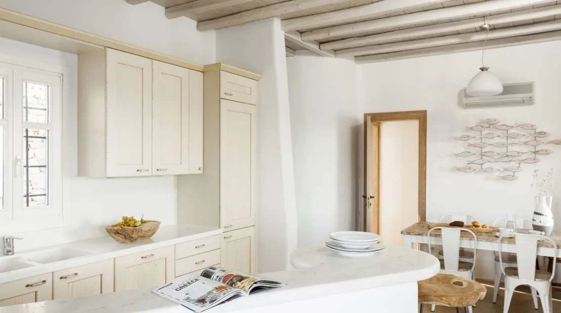 A bright kitchen and dining area with white cabinetry and a table.