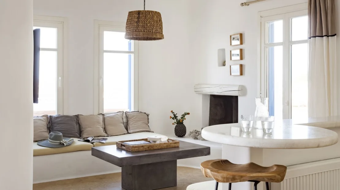A bright living room with seating, a fireplace, and a round dining table.