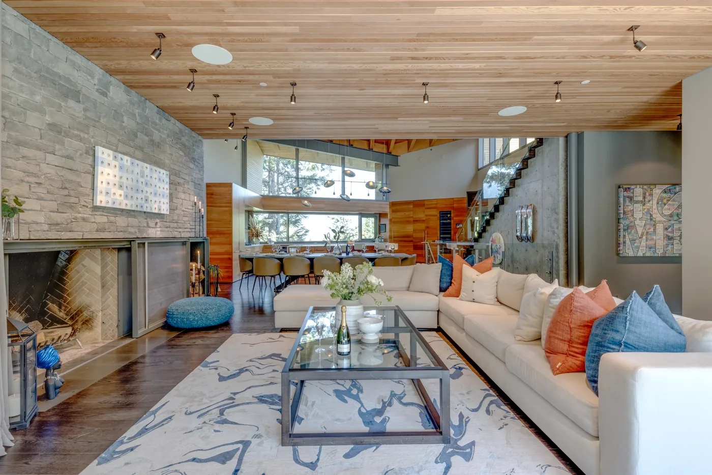Una amplia sala de estar con chimenea, asientos y grandes ventanas.