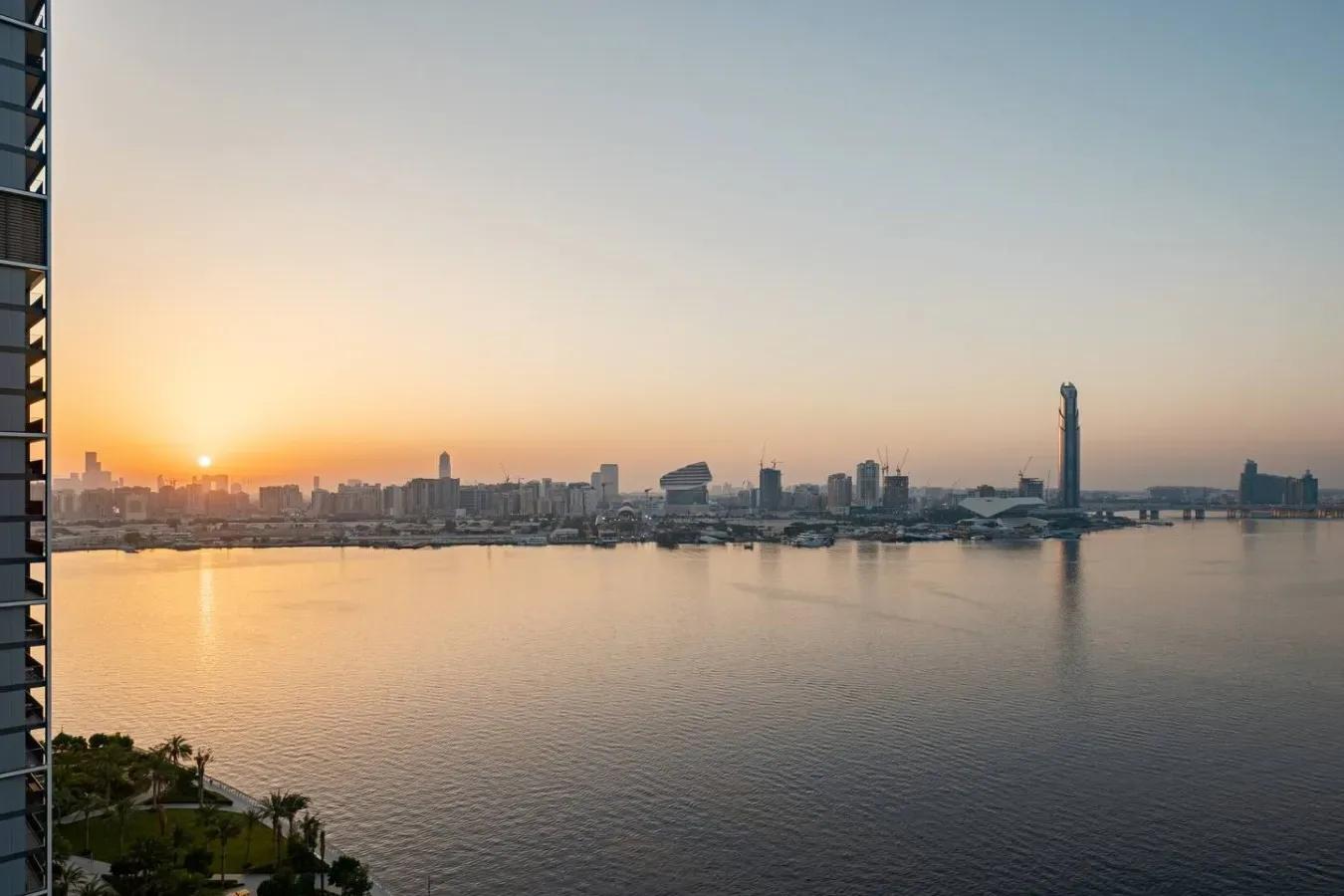 Un horizonte urbano se extiende al otro lado de una amplia costa al atardecer.