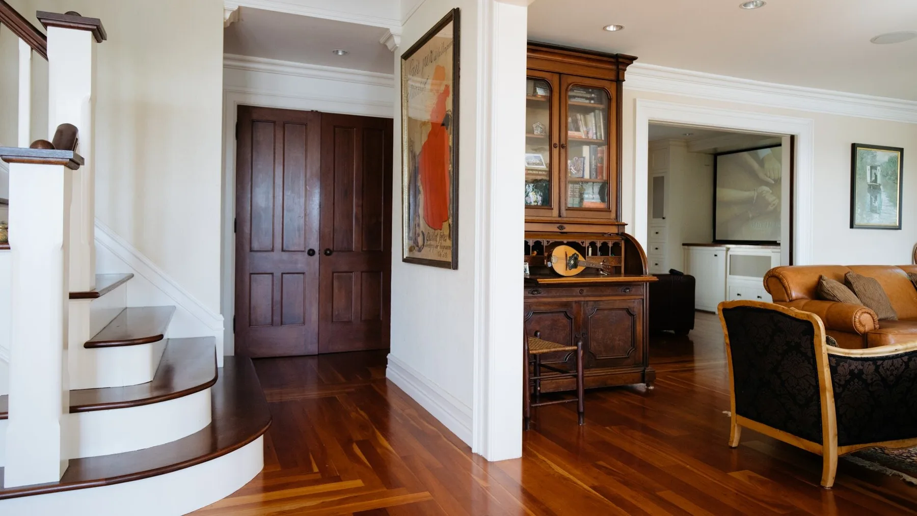 A bright interior hallway opens onto a living area, with polished wood flooring.
