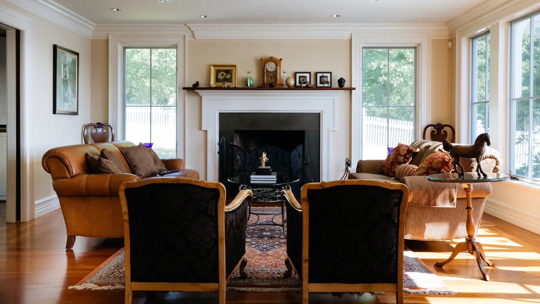 Una sala luminosa con chimenea, asientos y grandes ventanas.