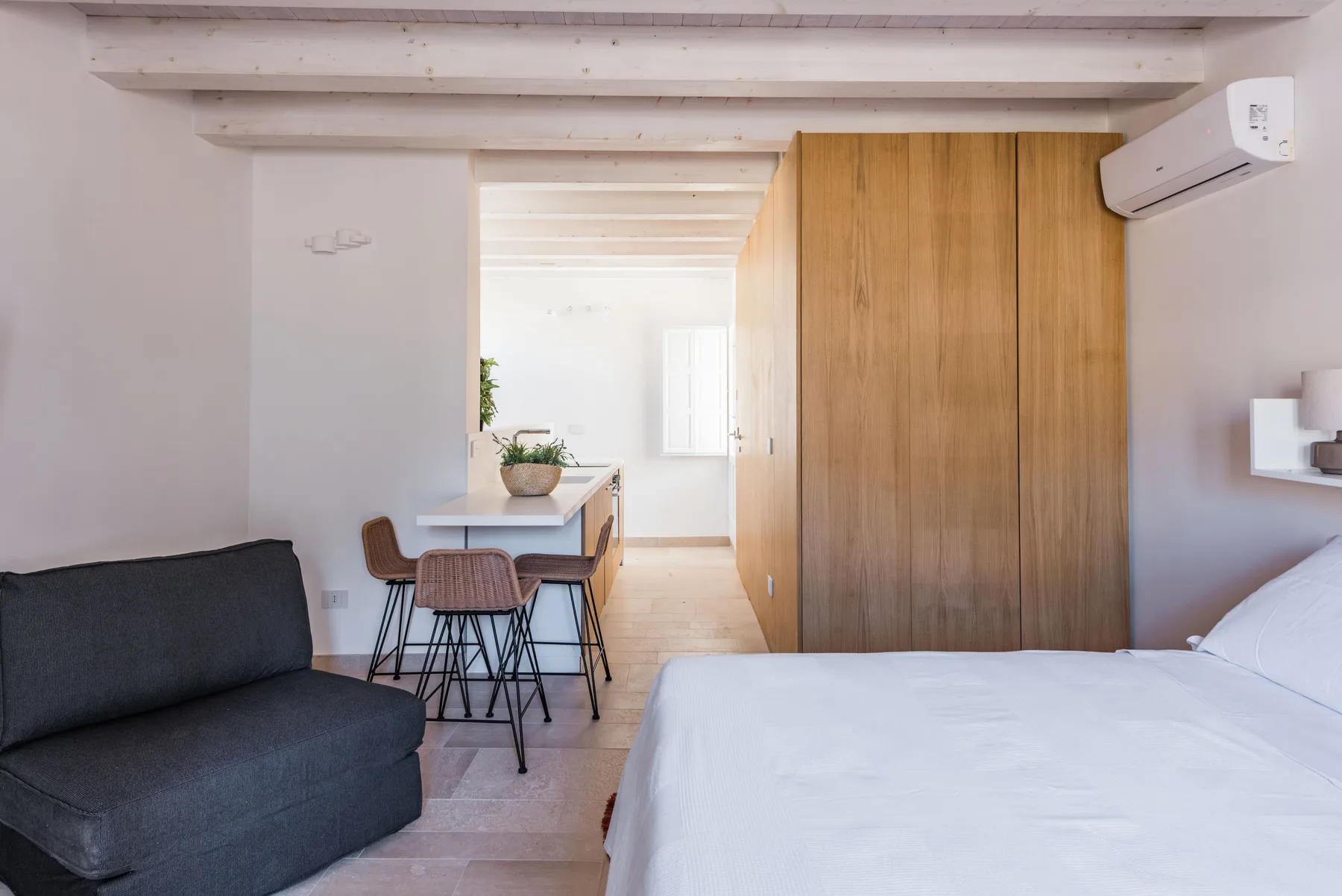 A bedroom with a bed, seating, and a small dining table.