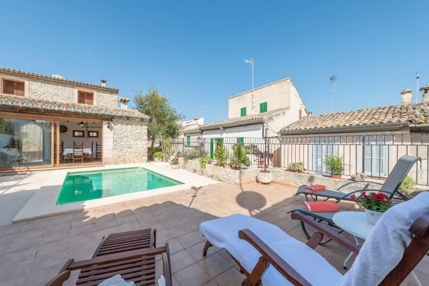 A sunny courtyard patio with a swimming pool and outdoor seating.
