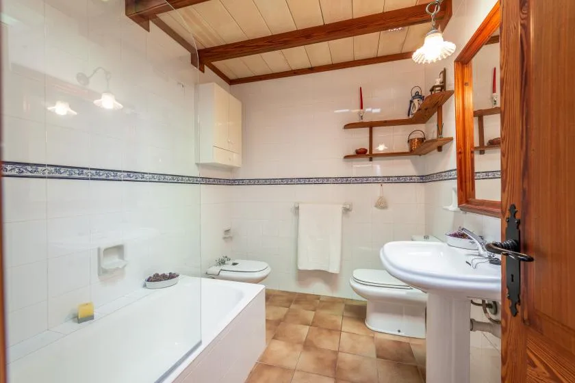 A tiled bathroom with a bathtub, sink, and toilet.