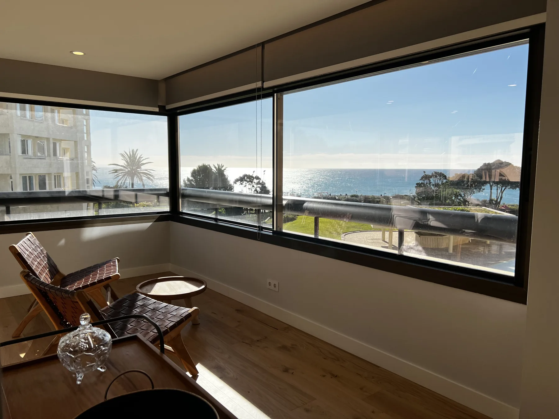 A sitting area with large windows overlooking the ocean.