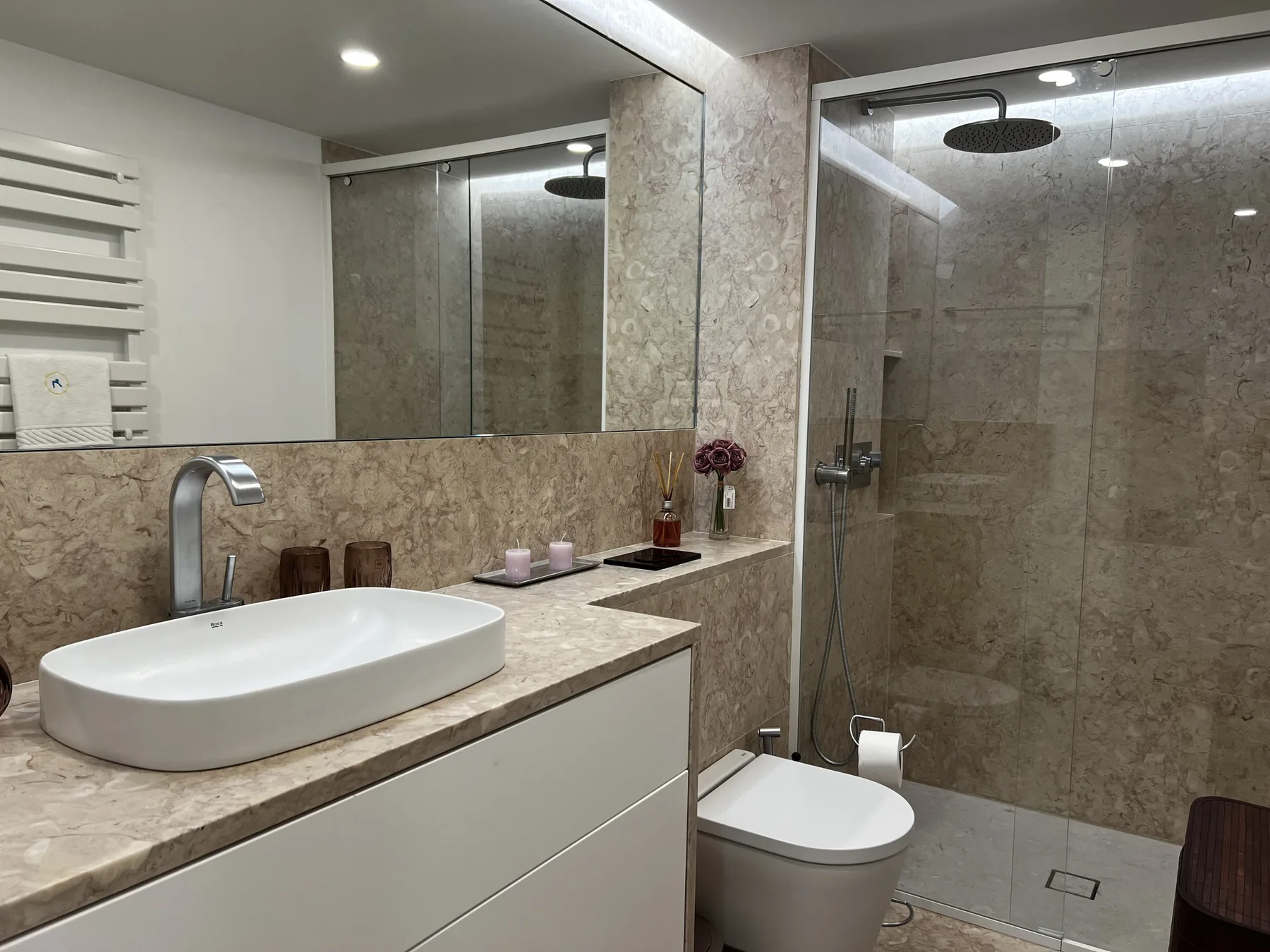 A bathroom with a sink, toilet, and glass shower.