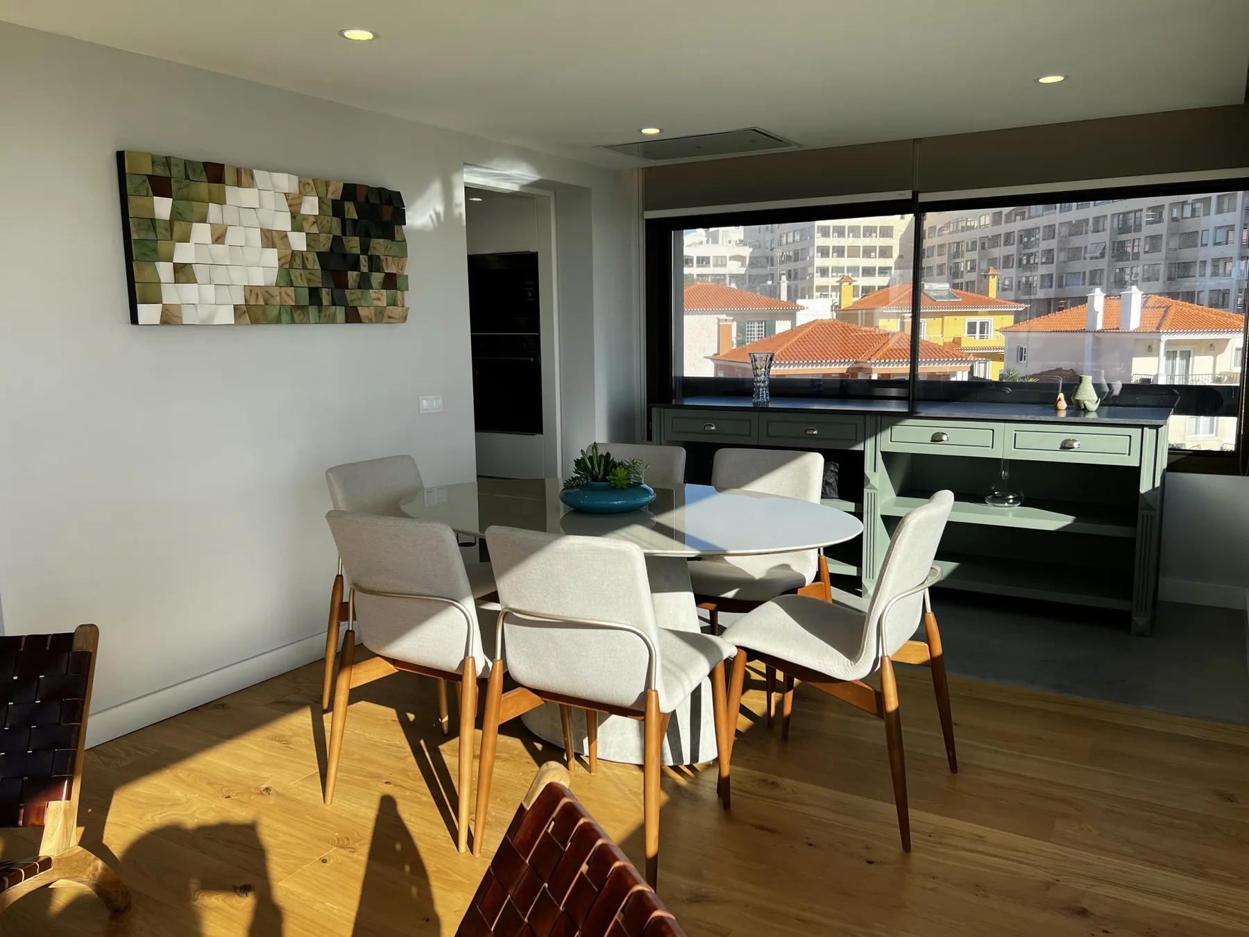 Comedor con una mesa y sillas junto a una ventana grande.