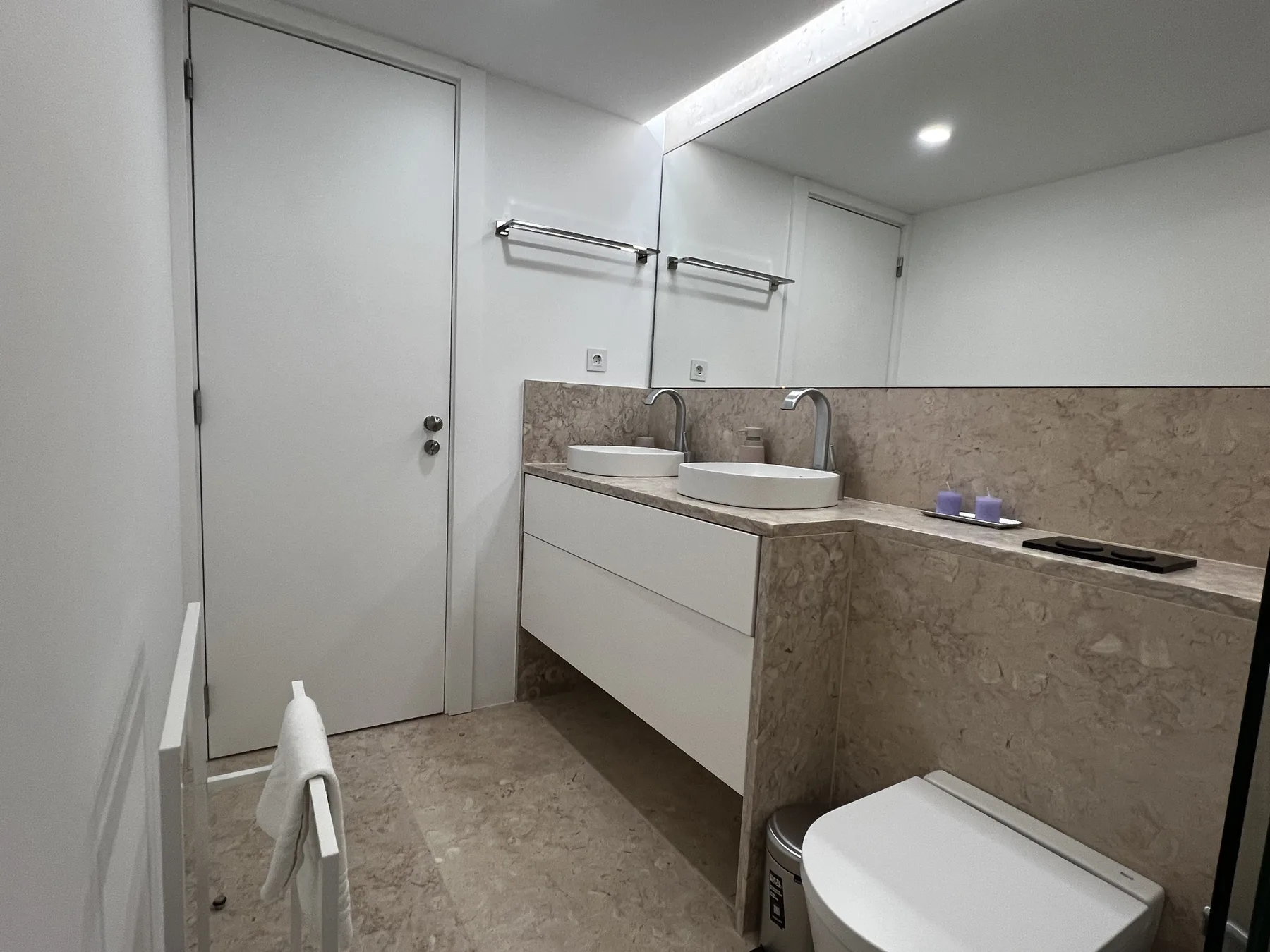 A modern bathroom with a double sink vanity and large mirror.