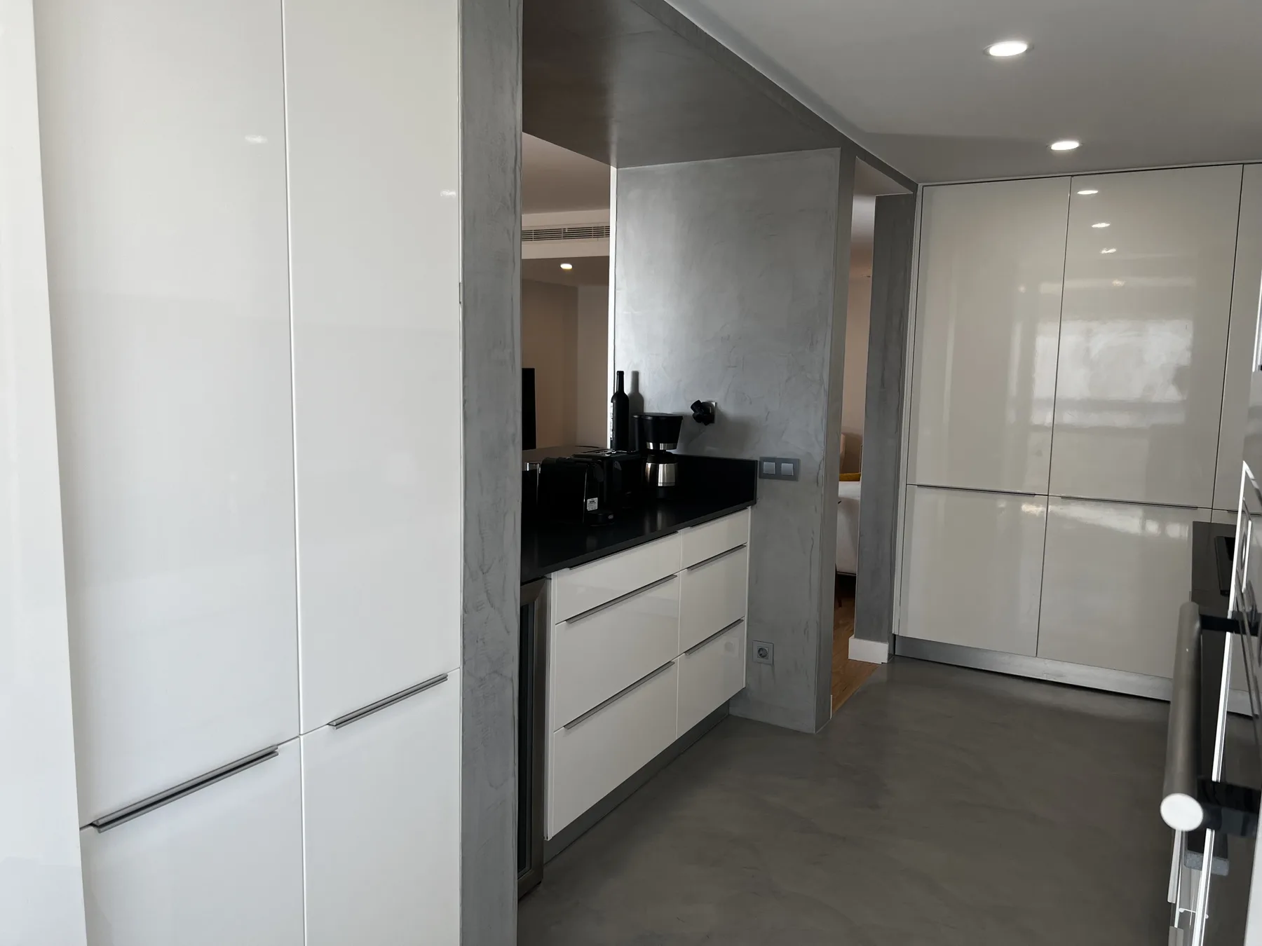 Una cocina moderna con armarios blancos y una encimera oscura.
