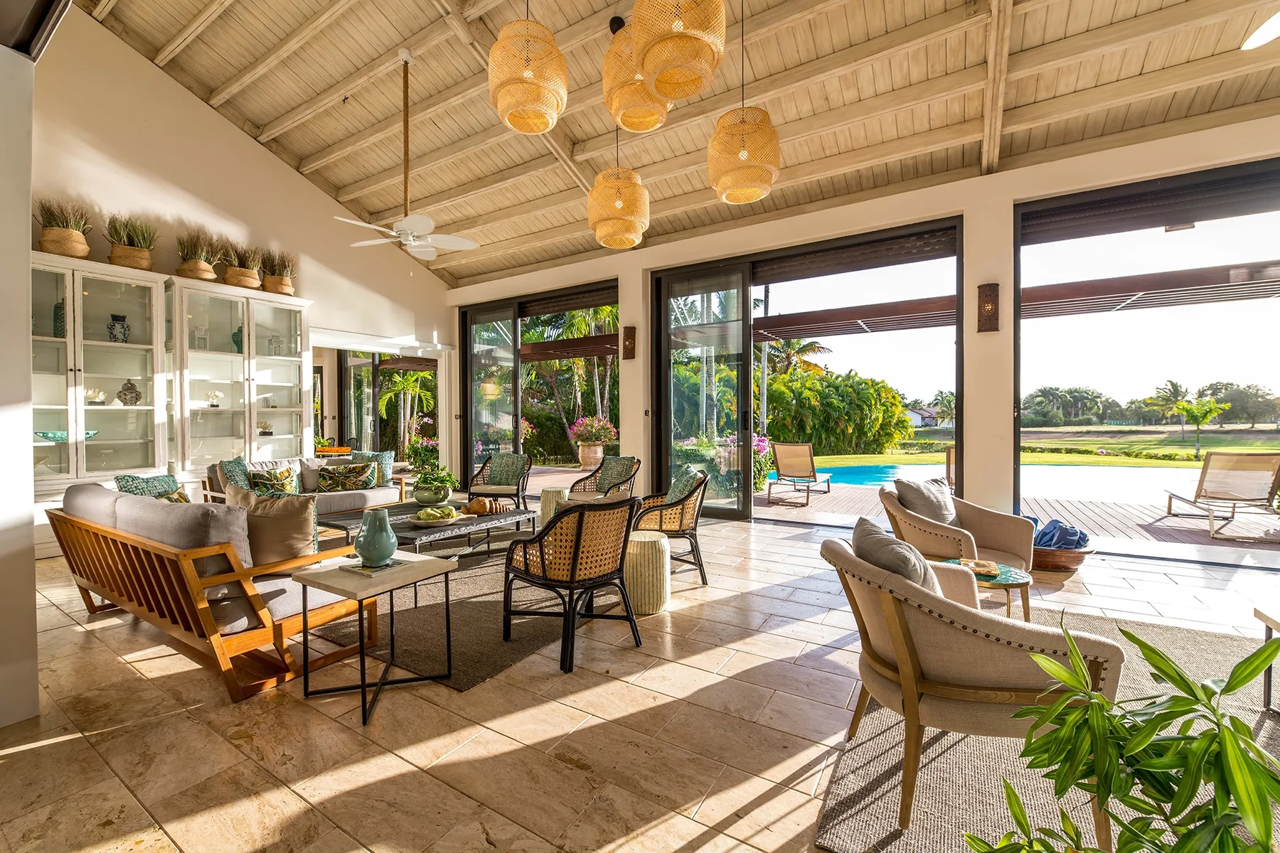 Una luminosa sala de estar se abre a un patio y un jardín con plantas.