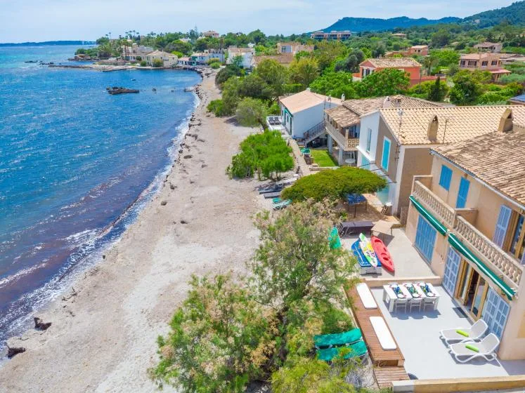 Aerial view of a seaside beach with coastal houses and boats.