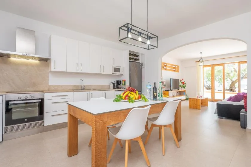 A bright open-plan kitchen and dining area with a central island and seating.