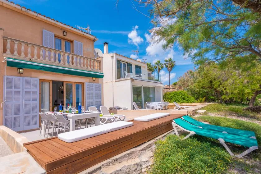 A sunny outdoor patio with dining seating, loungers, and a swimming pool.