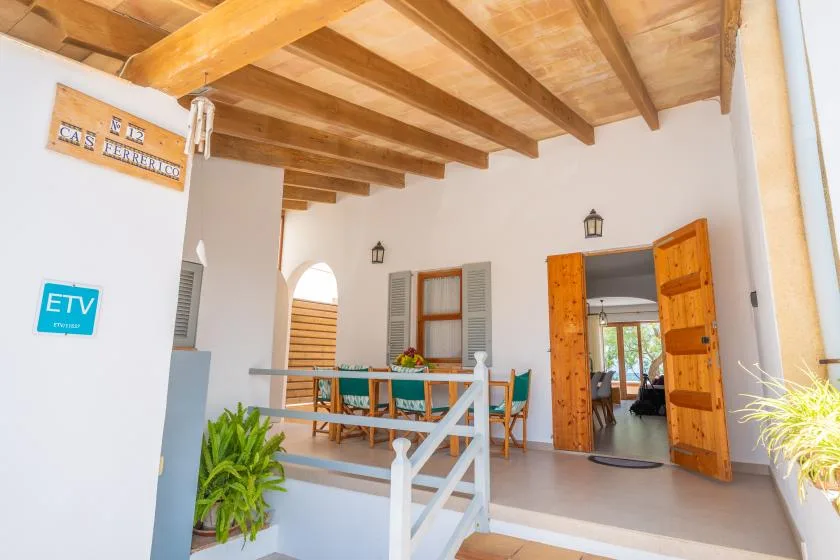 A bright dining area with a wooden ceiling and an open doorway.
