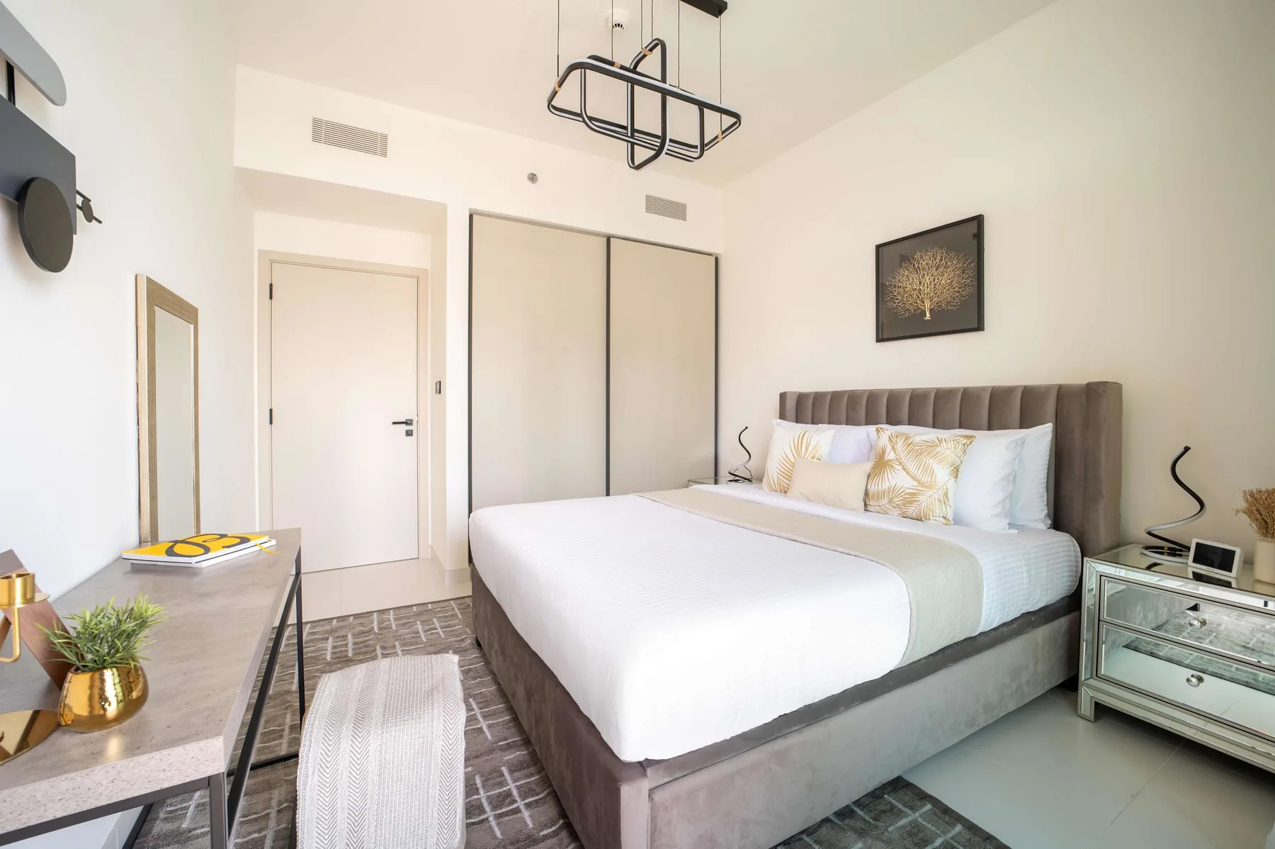 Un dormitorio luminoso con una cama bien tendida y mesitas de noche.