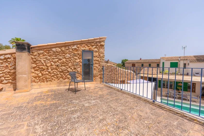 Una terraza soleada en la azotea da a una piscina y a edificios cercanos.