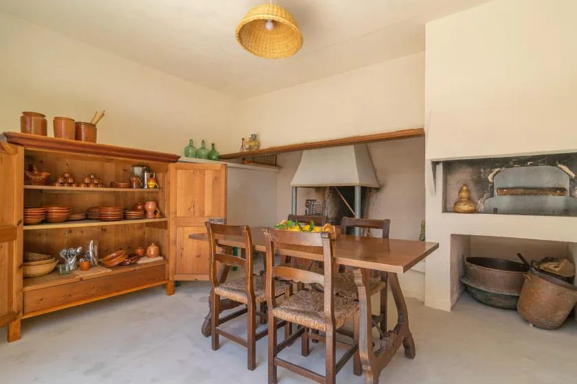 Un comedor rústico con una mesa de madera y estanterías abiertas.