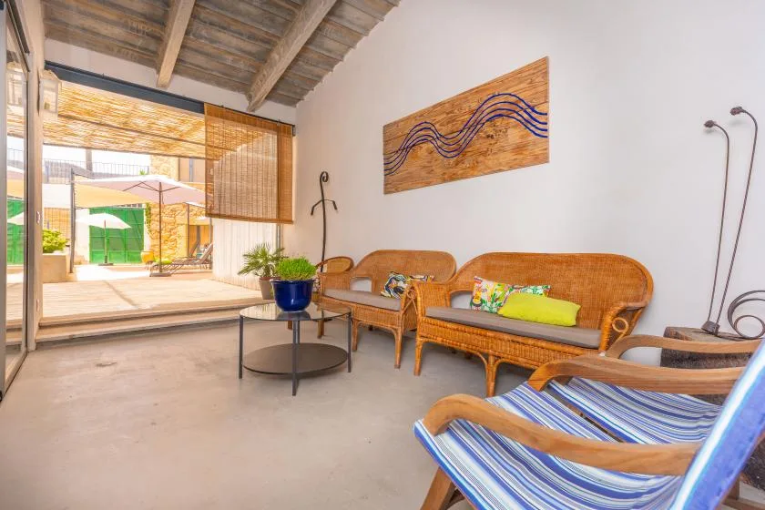 Una luminosa zona de estar con muebles de mimbre y vistas a un patio exterior.
