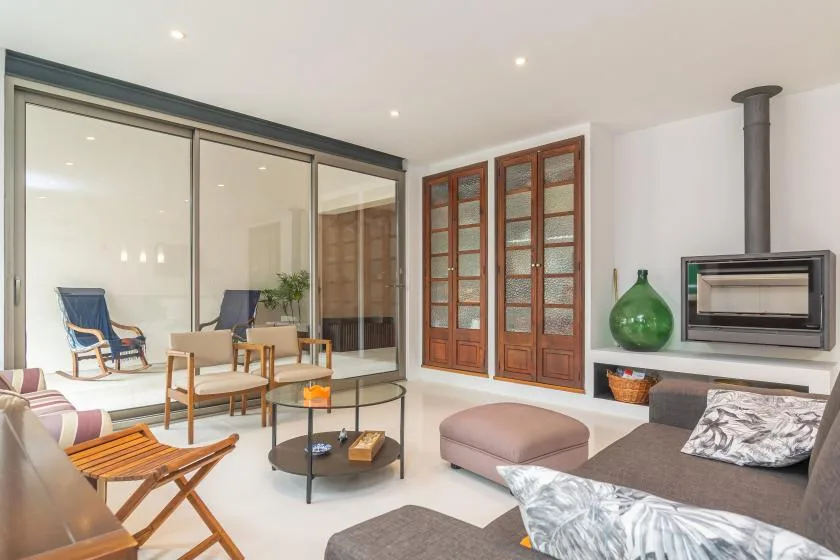 Una sala luminosa con asientos, una mesa de centro de vidrio y una chimenea.