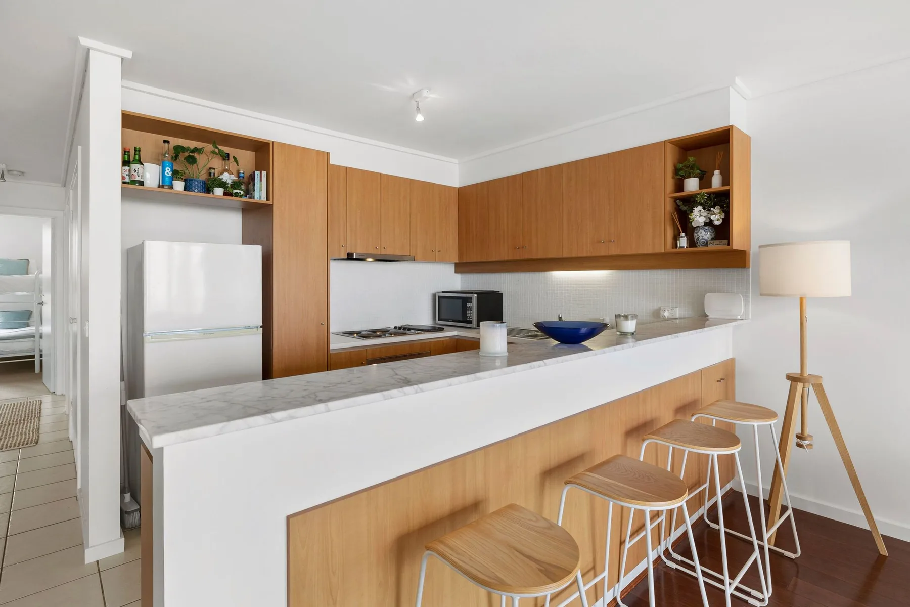 Una cocina moderna con gabinetes de madera y una larga isla blanca.