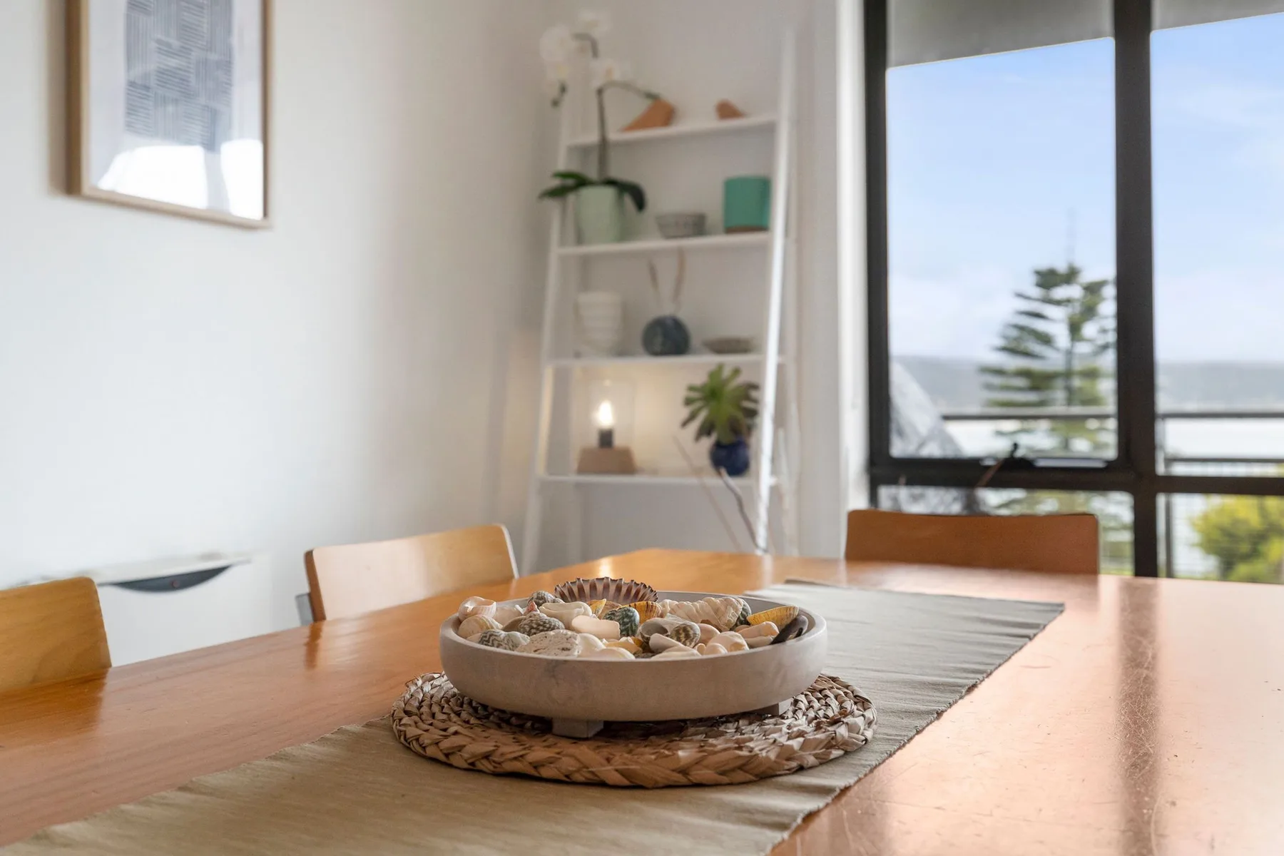 Un comedor con una mesa de madera junto a una ventana grande.