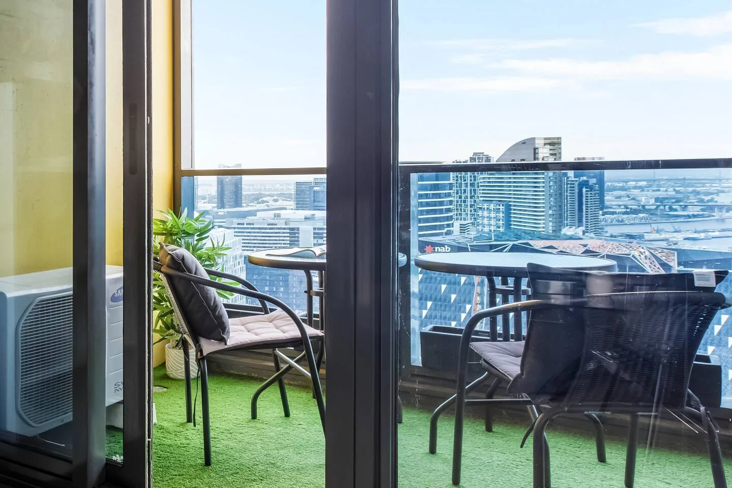 A balcony seating area overlooks nearby buildings.