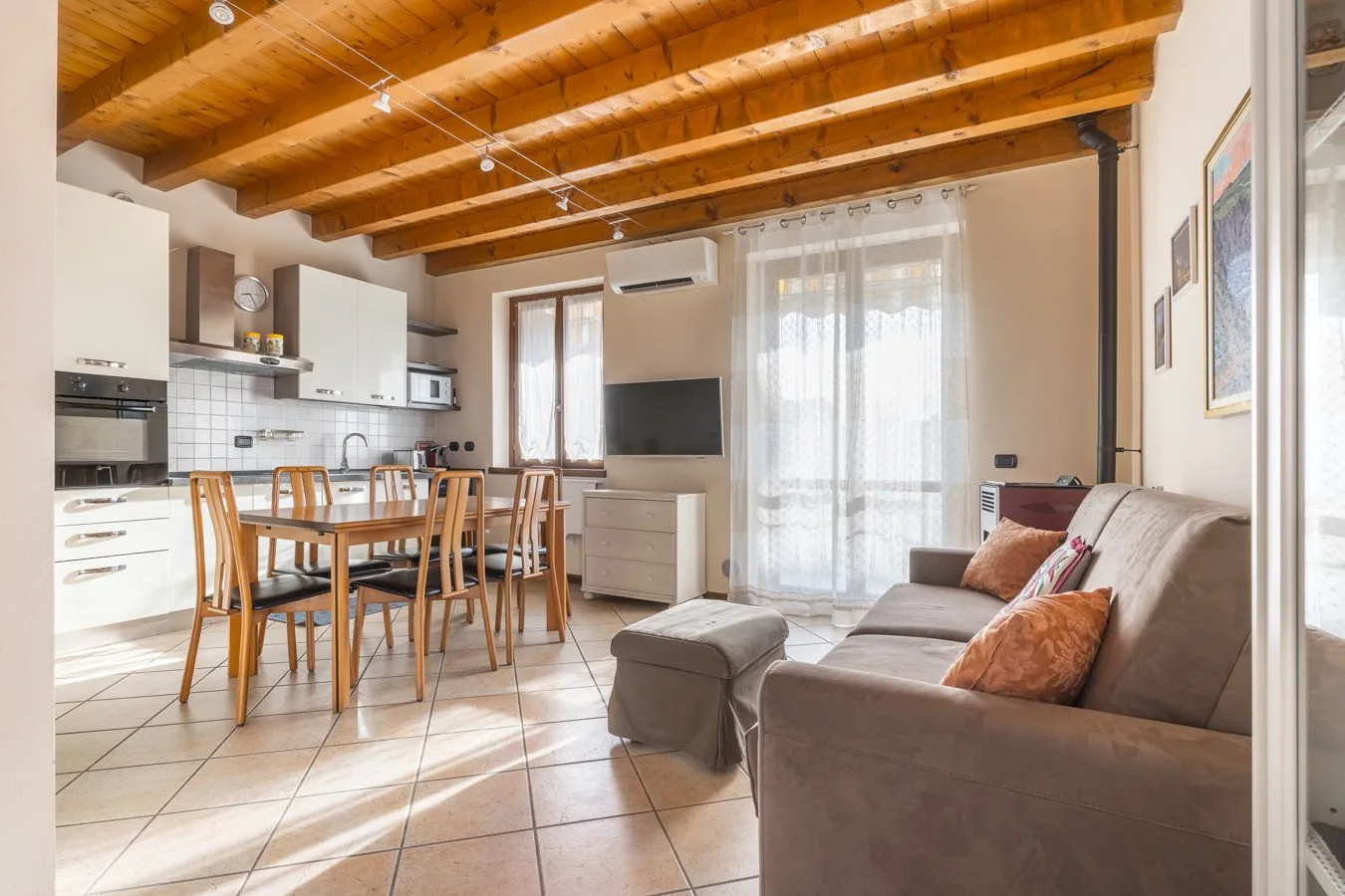 An open-plan living and dining area with a sofa and wooden dining table.