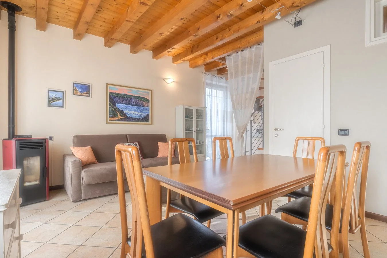 A dining area with a wooden table and seating beside a living area.