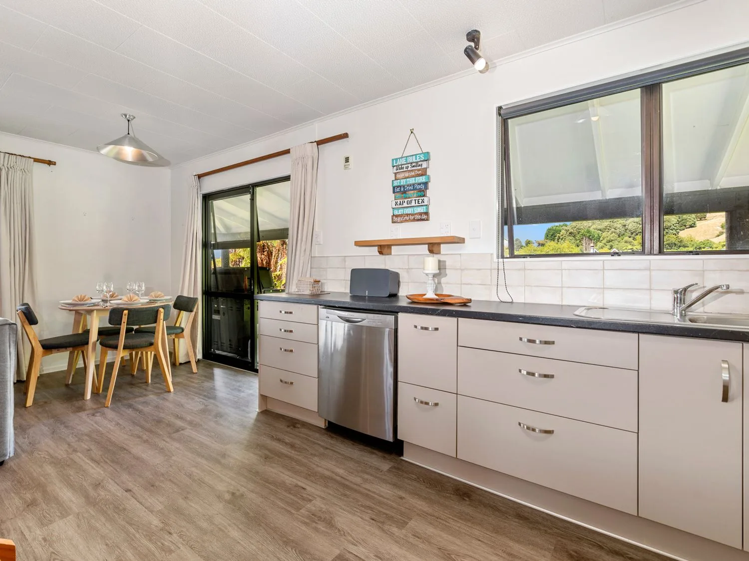 A kitchen and dining area with a table beside a glass door.