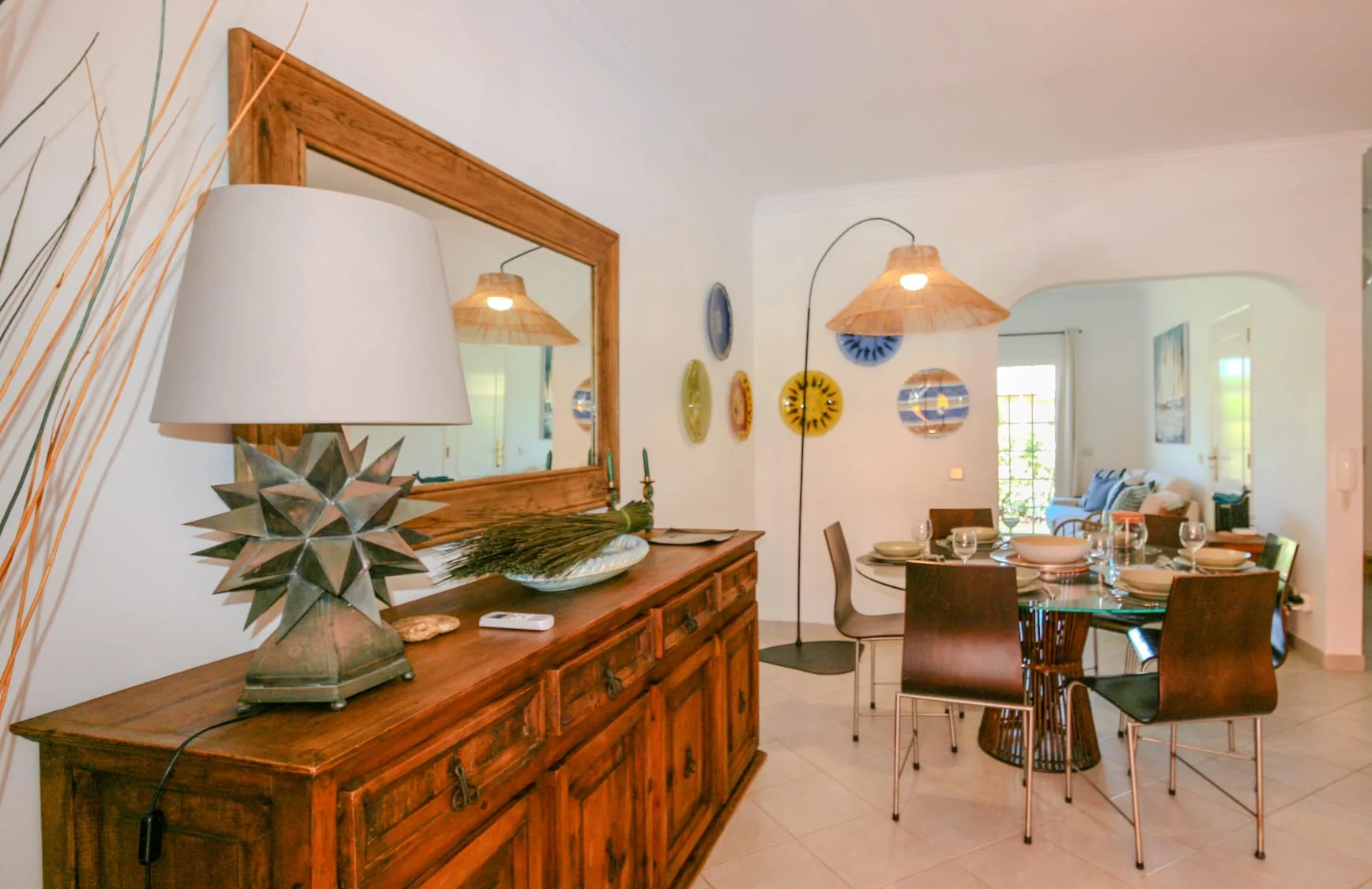 A dining area with a wooden table and chairs beneath a pendant light.