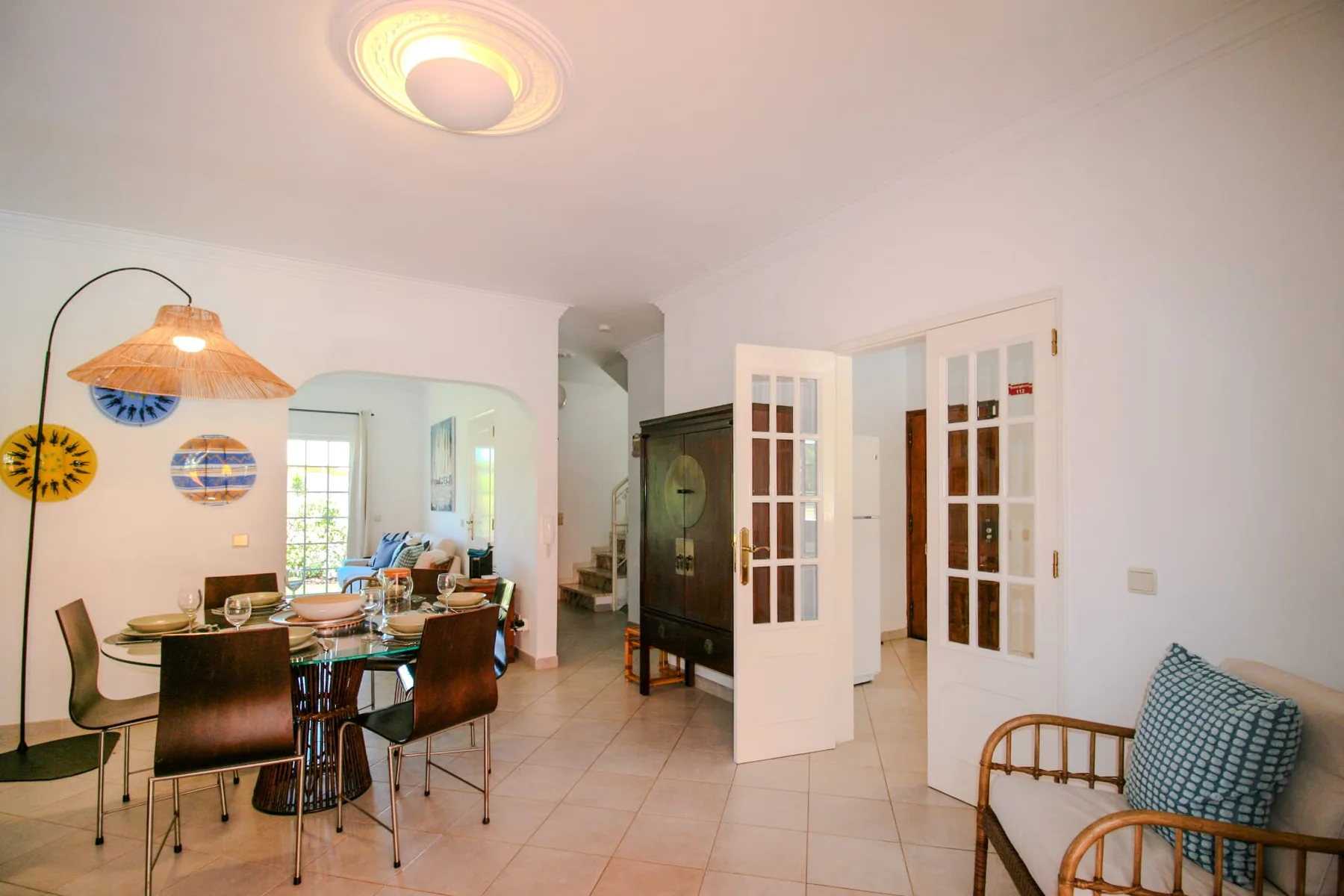 An open dining and sitting area with a table, chairs, and glass-paneled doors.