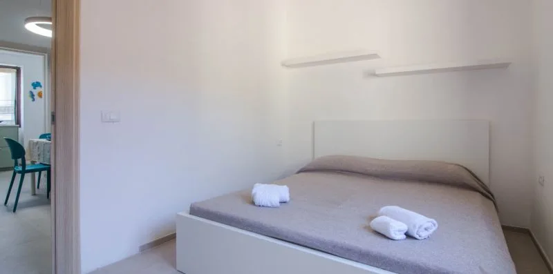 Un dormitorio con una cama y toallas dobladas encima.
