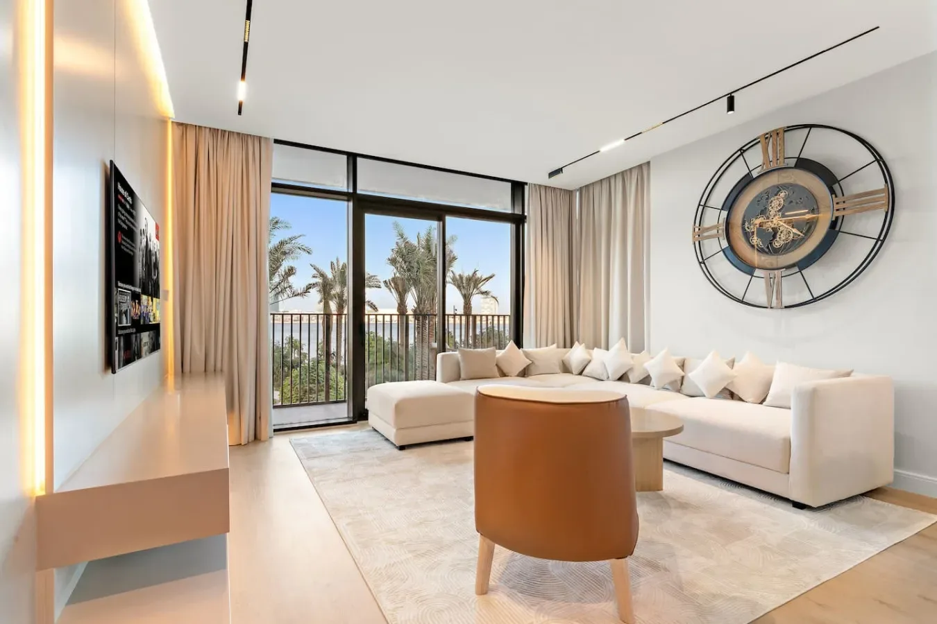 Una sala luminosa con una amplia zona de asientos y puertas de vidrio que dan a un balcón.