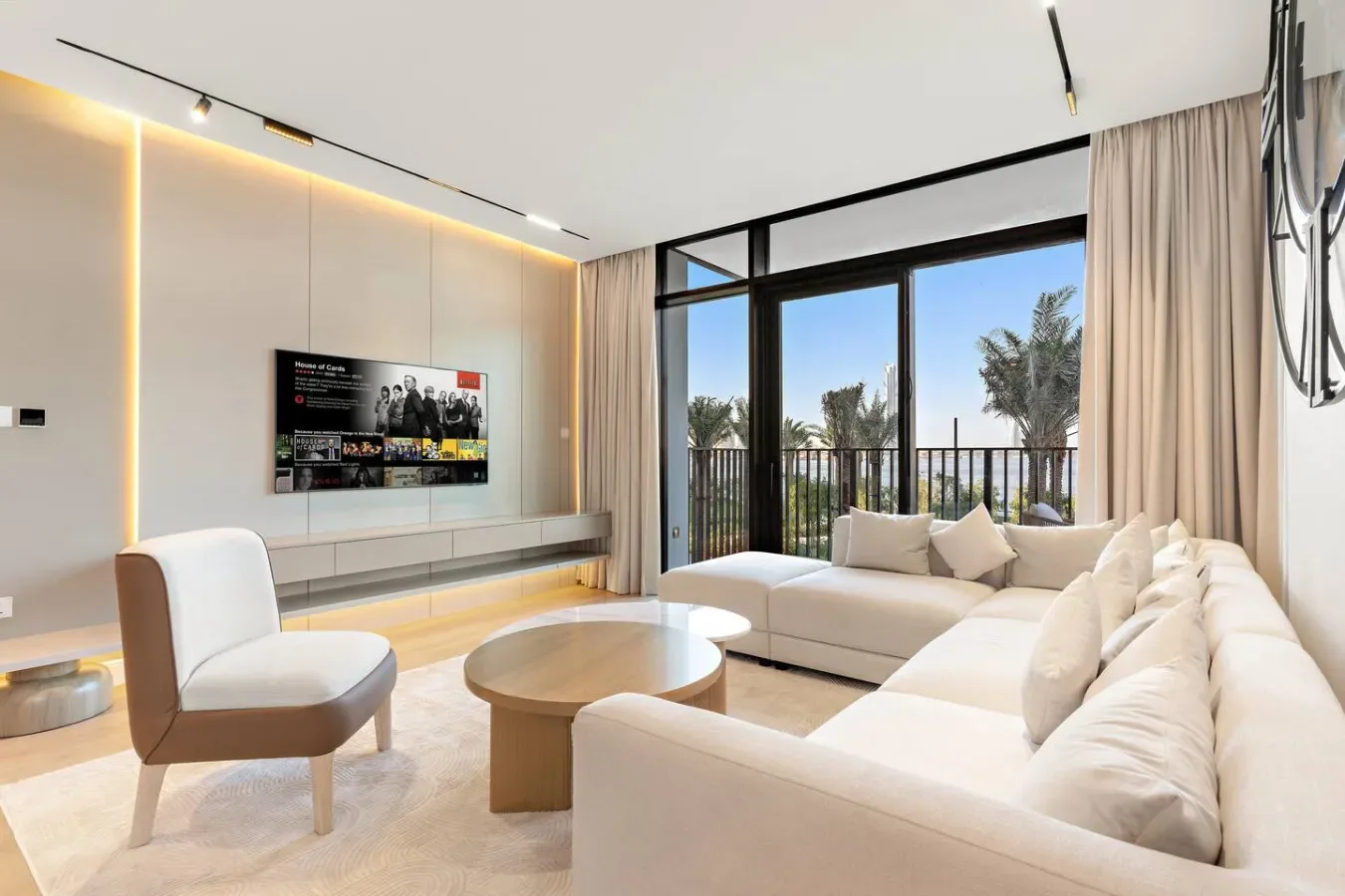 Una sala luminosa con asientos claros y una ventana amplia que da a un balcón.