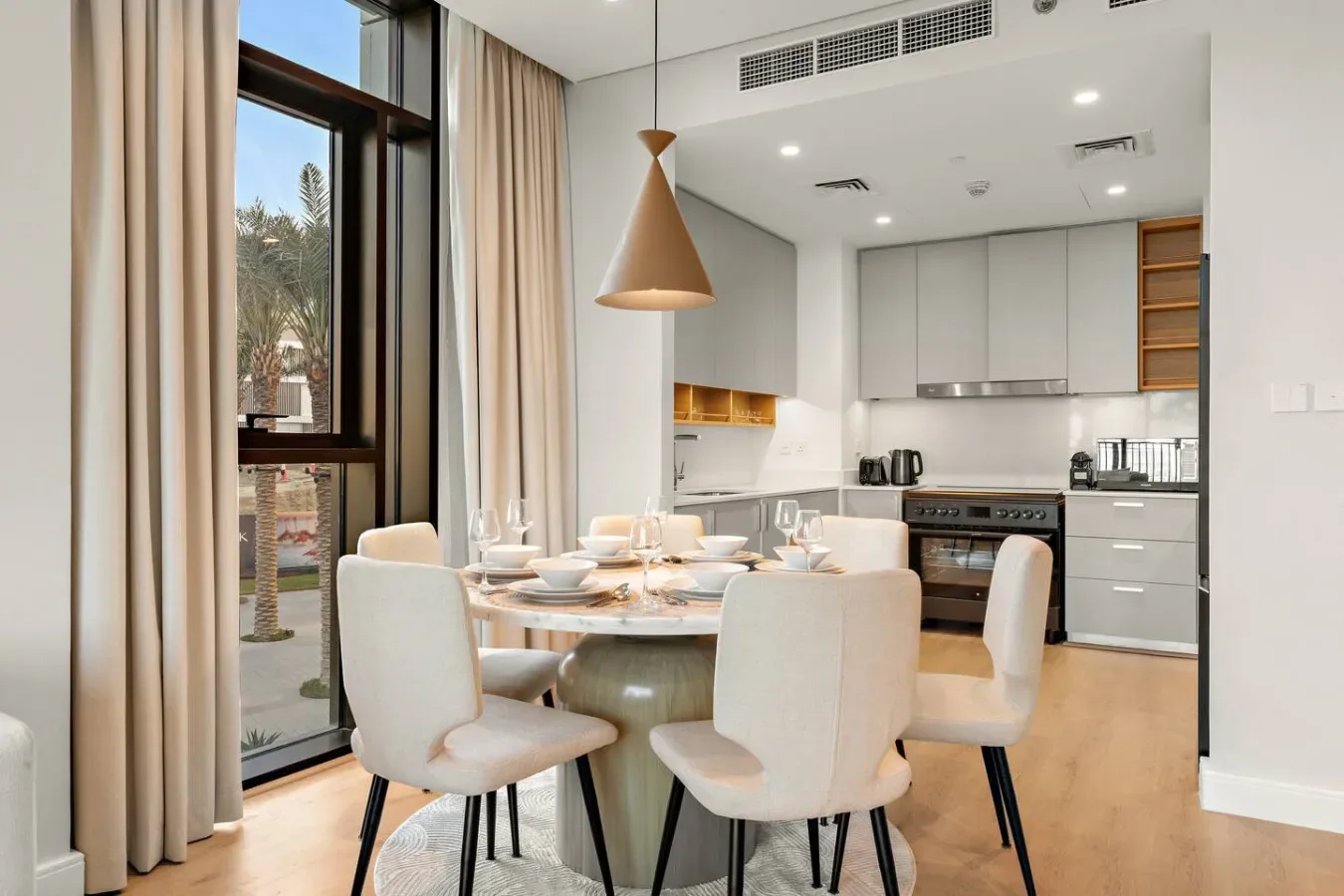 Un comedor con una mesa redonda y sillas junto a una cocina moderna.