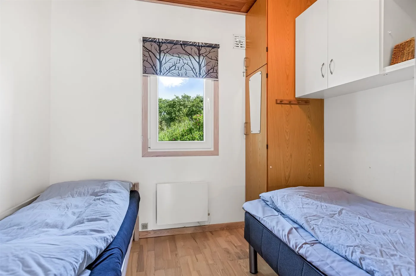 Dormitorio con dos camas y una ventana.