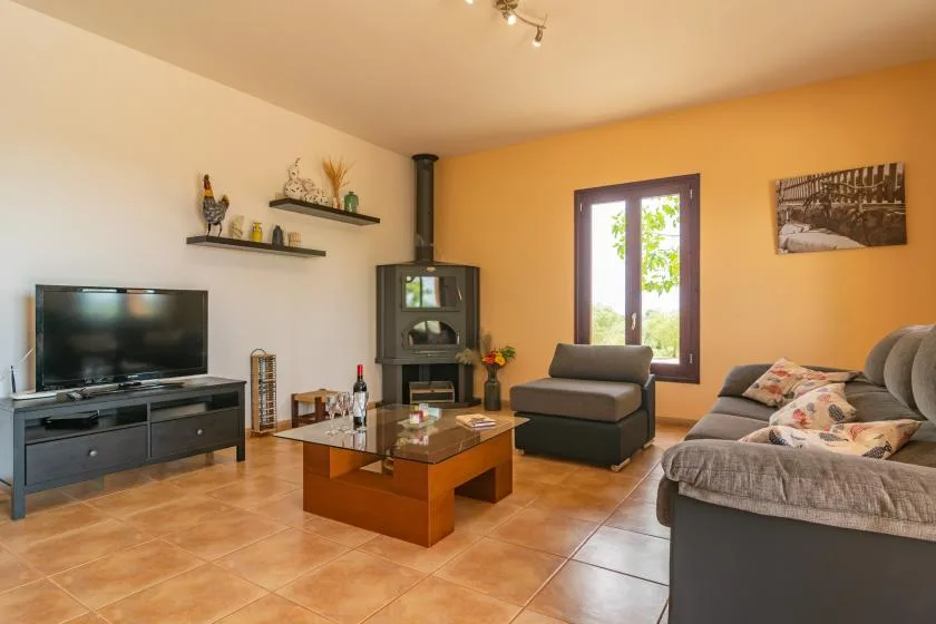 Una sala de estar con televisión, asientos y una mesa de centro.