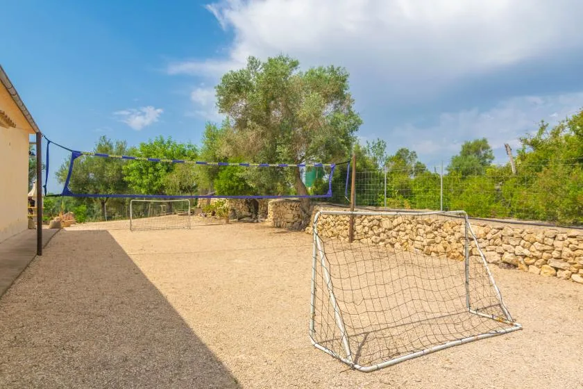 Una zona recreativa al aire libre tiene una red de voleibol y una portería pequeña.