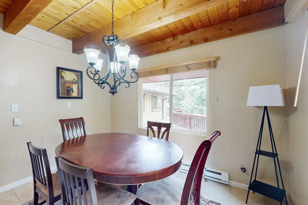 A dining area with a round table beneath a wooden ceiling.