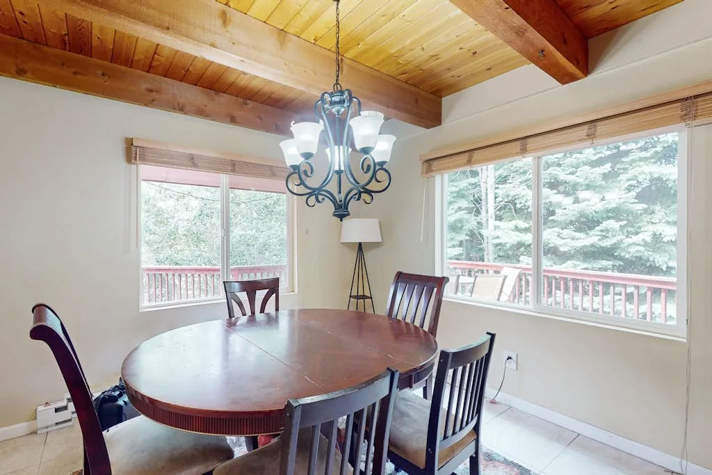 A dining area with a round table beneath a wooden ceiling.